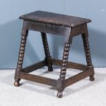 An oak "joint" stool of "17th Century" design, with bobbin turned legs, plain stretchers and top