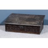 A 17th Century oak bible box with sloping lid, the front carved with stylised Fleur-de-lis ornament,