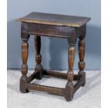 A 17th Century oak joint stool, the plain top with moulded edge, on turned supports and plain