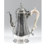 A George V silver baluster shaped coffee pot of "early George III" design, the domed cover with