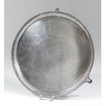 A George V silver circular salver with rope pattern rim, pierced border and on three pierced panel