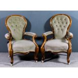 A pair of Victorian mahogany framed spoon back open arm easy chairs, with moulded showwood frames,