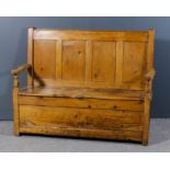 A 19th Century stripped pine box settle with four panelled back, twin lifting lid to seat and shaped