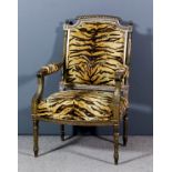 A gilt framed open armchair of "Louis XV" design with gadroon carved cresting on fluted uprights,