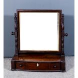 A 19th Century mahogany framed rectangular toilet mirror on turned uprights, the bow and break front