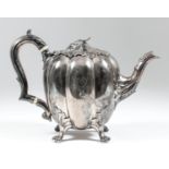 A William IV silver melon pattern teapot with leaf pattern finial and leaf capped high scroll