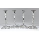 A set of four George IV silver pillar candle sticks of "mid 18th Century" design, with turned and