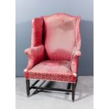 A George III mahogany wing back easy chair with arched back, deep wings and outscroll arms,