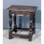 A 17th Century oak joint stool, the plain top with moulded edge, on baluster turned supports and