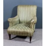 An Edwardian scroll back easy chair with out-scroll arms upholstered in green and cream striped