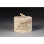 A JAPANESE MEIJI PERIOD OVAL TUSK SECTION LIDDED BOX, the body carved in shallow relief with on