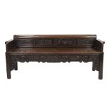 A LATE 19TH CENTURY CHINESE HARDWOOD BENCH, the low back with six panels carved in relief with