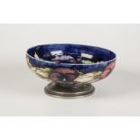TUDRIC MOORCROFT PANSY PATTERN TUBE LINED POTTERY BOWL WITH PLANISHED PEWTER FOOT, of shallow, steep