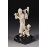 FINE QUALITY 19TH CENTURY JAPANESE CARVED IVORY OKIMONO OF A FARMER AND HIS SON kneeling at his feet