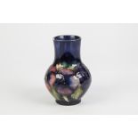 WALTER MOORCROFT PANSY PATTERN TUBE LINED POTTERY VASE, of footed baluster form with cylindrical