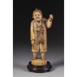 A 19TH CENTURY JAPANESE WALL CARVED ONE PIECE IVORY OKIMONO of a man with two knives tucked into his