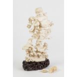 CHINESE EARLY TWENTIETH CENTURY CARVED ONE PIECE CARVED IVORY FIGURE, of a smiling male deity