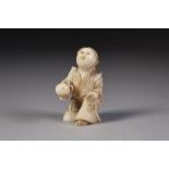 A SMALL JAPANESE MEIJI PERIOD CARVED IVORY KNEELING FIGURE holding in outstretched right hand a