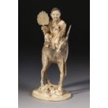 A JAPANESE CARVED AND STAINED IVORY OKIMONO OF A BEARDED SAGE HOLDING A FAN AND SCROLL seated on the