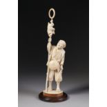 A JAPANESE MEIJI PERIOD TOKIO SCHOOL CARVED IVORY OKIMONO OF A SARUMAWASHI (MONKEY TRAINER)