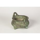 A CHINESE BRONZE SHALLOW CENSER with two pierced handles, standing on three tapered felt, bearing