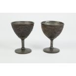 PAIR OF 18th/19th CENTURY CHINESE CARVED COCONUT SHELL AND PEWTER LINED STEMMED CUPS each with a 'V'