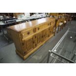 A 'JAYCEE' CARVED OAK SIDEBOARD WITH THREE DRAWERS ABOVE FOUR CUPBOARD DOORS
