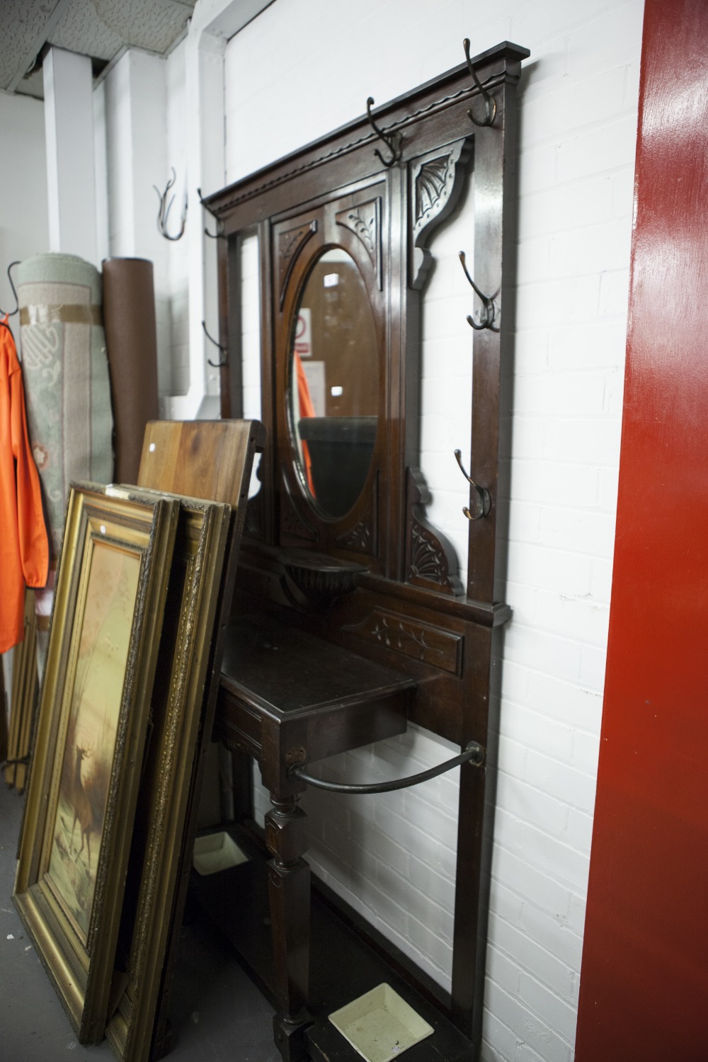 A VICTORIAN MAHOGANY HALL STAND, THE CENTRAL OVAL MIRROR OVER SHELF, CARVED DECORATION THROUGHOUT,