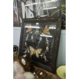 A BLACK BACKED EMBROIDERED FIRE GUARD, FEATURING BUTTERFLY, IN OAK CARVED FRAME