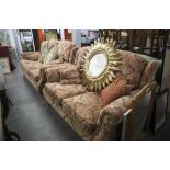 A PARKER KNOLL THREE PIECE SUITE, COVERED IN GOLD AND RED DAMASK, COMPRISING A THREE SEATER, TWO