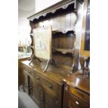 A REPRODUCTION OAK DRESSER, THE RAISED BACK WITH TWO SHELVES, THE BASE WITH TWO DRAWERS AND THREE