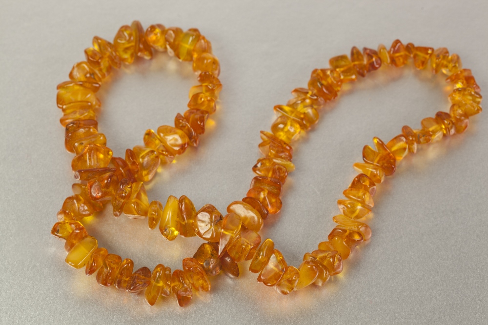 SINGLE STRAND NECKLACE OF GOLDEN AMBER CHIPS AND TWO METAL CHAIN NECKLACES, with large pendant set - Image 3 of 3