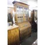 AN EARLY TWENTIETH CENTURY WELL CARVED OAK BUREAU BOOKCASE, THE UPPER CABINET WITH COLOURED LEADED