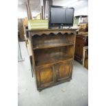 CIRCA 1920'S OAK OPEN BOOKCASE WITH A PAIR OF PANEL DOORS TO BOTTOM, ON TURNED FRONT SUPPORTS AND