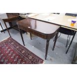 AN ANTIQUE MAHOGANY FOLD OVER CARD TABLE ON TURNED TAPERING SUPPORTS