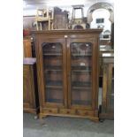 MAHOGANY BOOKCASE, HAVING TWO GLAZED DOORS AND THREE DRAWERS BELOW ON BRACKET FEET