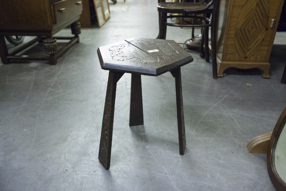 A CARVED OAK HEXAGONAL LOW JARDINIÈRE STAND ON THREE TRIANGULAR SUPPORTS