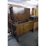 OAK DROP-LEAF DINING TABLE ON HEAVY CUP AND COVER SUPPORTS AND AN OAK ENCLOSED SIDEBOARD WITH