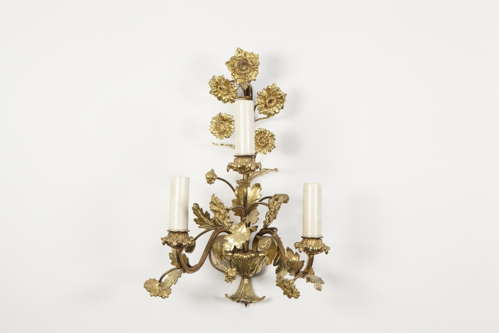 SET OF FOUR FLORAL CAST ORMOLU THREE BRANCH WALL LIGHTS, each modelled with foliate scroll arms