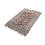 PAKISTAN BOKHARA, FINELY KNOTTED RUG, the crimson field filled with two rows of diamond shaped