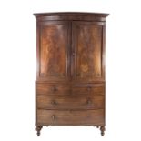 WILLIAM IV FLAME CUT MAHOGANY AND EBONY LINE INLAID BOW FRONTED CLOTHES PRESS, the moulded cornice
