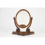 VICTORIAN CARVED MAHOGANY TOILET MIRROR, the oval plate in a moulded frame, flanked by scroll