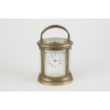 A LATE 19TH CENTURY REPEAT CARRIAGE CLOCK in scroll engraved brass oval case with four curved