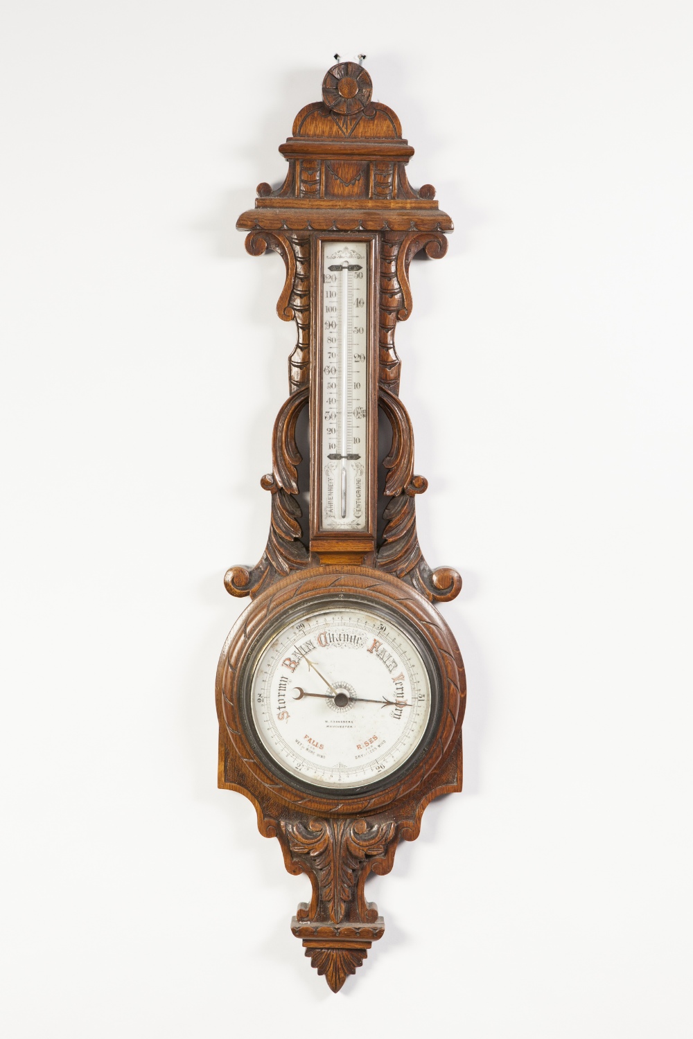 W. ARONSBERG, MANCHESTER, CARVED OAK ANERIOD BAROMETER, the 6" dial in a scroll carved banjo