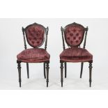 PAIR OF LATE VICTORIAN EBONISED AND CARVED SINGLE CHAIRS, each with deep buttoned shield shaped back