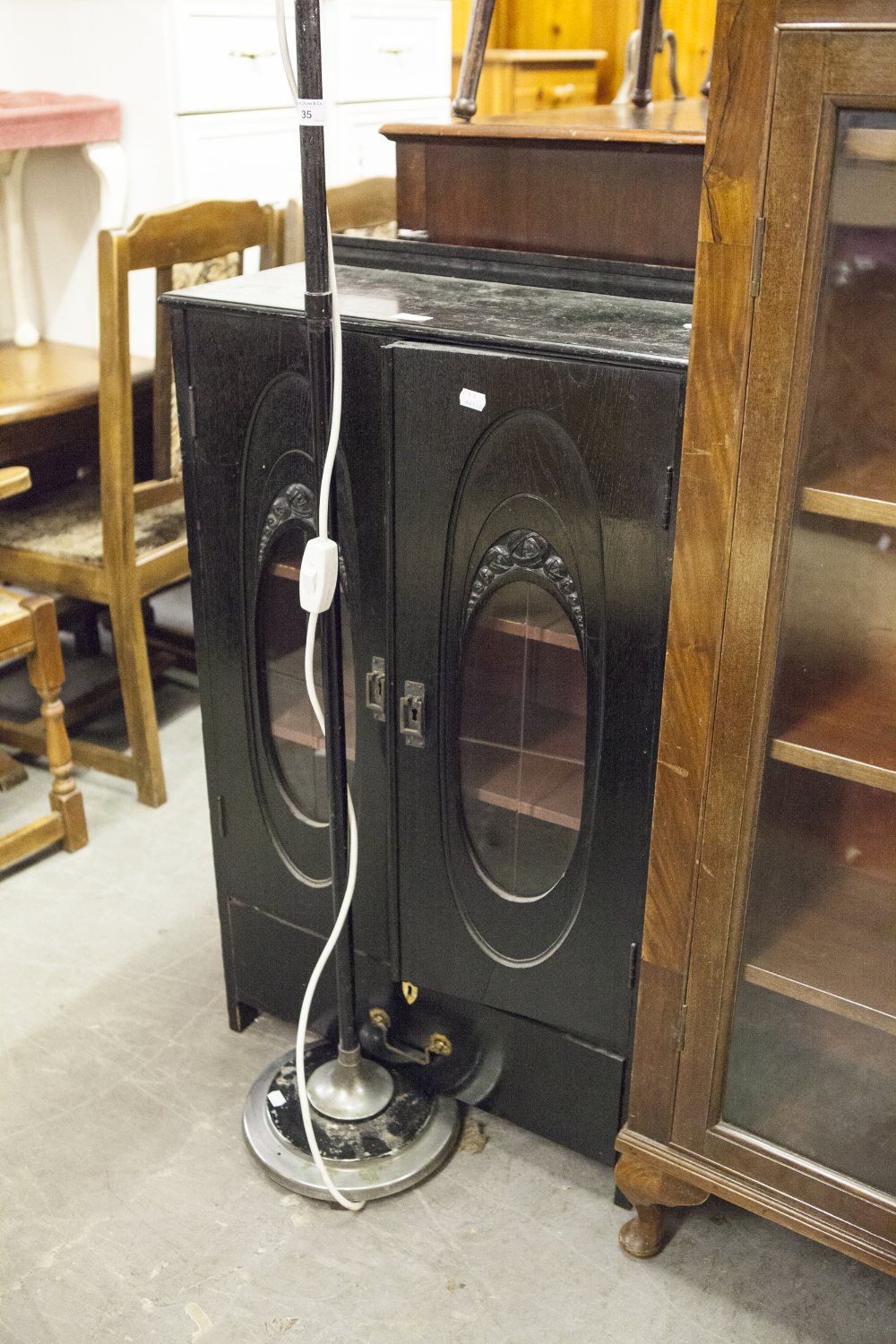 EBONISED MUSIC CABINET WITH TWO GLAZED DOORS ENCLOSING SHELVES AND HAVING A DRAWERS BELOW (2'1"