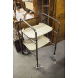 A WALKER WITH TRAYS, A FOLDAWAY CHAIR AND A ZIMMER FRAME (3)