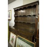 A REPRODUCTION OAK DRESSER, THE RAISED BACK WITH TWO SHELVES, THE BASE WITH TWO DRAWERS AND THREE