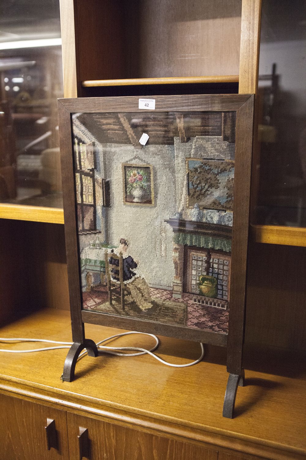 A VICTORIAN FIRE SCREEN, OAK FRAME WITH NEEDLEWORK SCENE OF A SEATED WOMAN READING