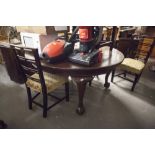 AN EARLY TWENTIETH CENTURY D-END DINING TABLE, EXTENDING WITH A WINDING ACTION, ON FOUR CARVED